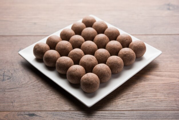 Nachni laddu o Ragi laddoo o palline fatte con miglio, zucchero e burro chiarificato. È un alimento salutare dall'India. Servito in una ciotola o piatto con crudo intero e polvere. Messa a fuoco selettiva