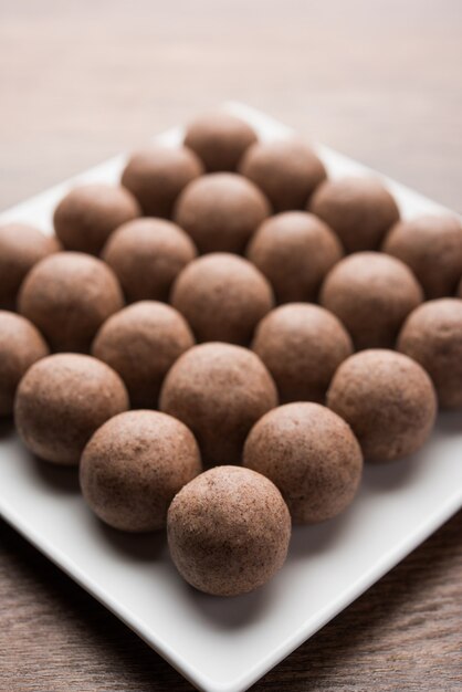 Nachni laddu o Ragi laddoo o palline fatte con miglio, zucchero e burro chiarificato. È un alimento salutare dall'India. Servito in una ciotola o piatto con crudo intero e polvere. Messa a fuoco selettiva