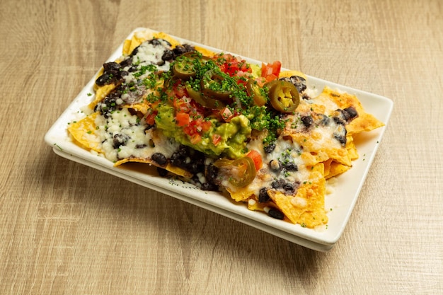 Nachos con formaggio e guacamole tipico cibo messicano.