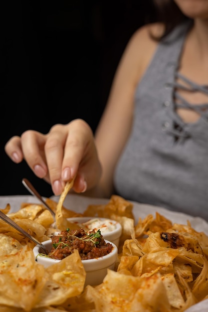 Nachos con salse su piatti su un tavolo di legno