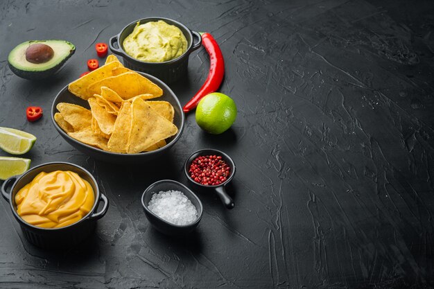 Nachos messicani con salsa insieme, sulla tavola nera