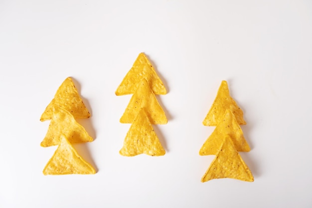 Nachos messicani di patatine di mais disposti sotto forma di un albero di Natale su uno sfondo bianco