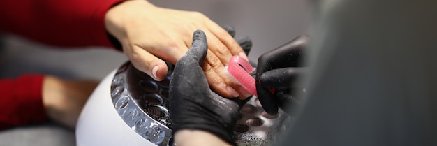 Nail master che pulisce le mani dei clienti dalla polvere con una spazzola speciale