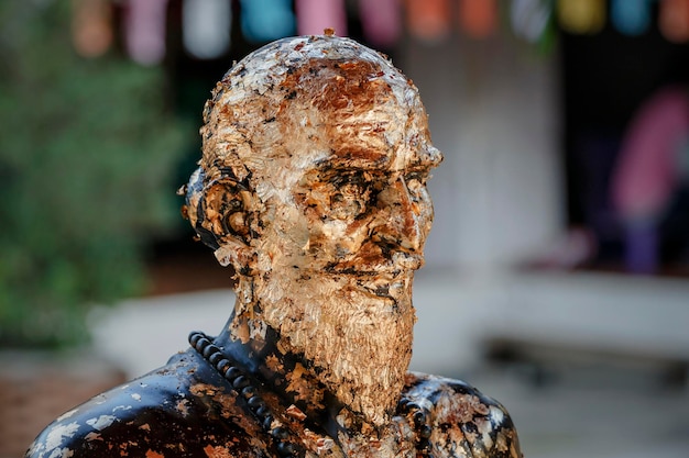 Nan, Thailandia, Wat Phrahat Che Heng Tempio. Un luogo di culto sacro situato sul lato est del fiume Nan. Scultura di un uomo ricoperto di pezzi di foglia d'oro