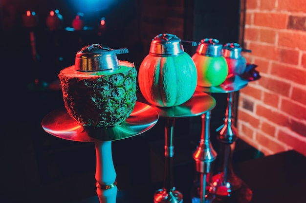 Narghilè shisha rosso con fumo e scintille rosse su sfondo di arte in mattoni da tavolo in legno Concetto Shisha