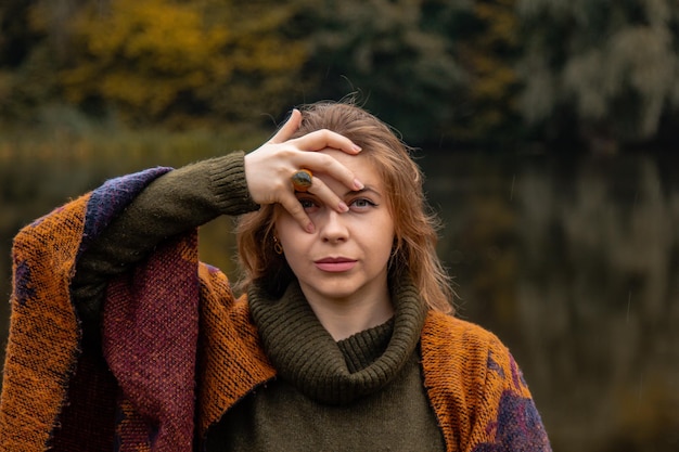 Nascondino la ragazza si coprì il viso con le mani Ritratto del primo piano su uno sfondo del lago Il concetto di dolore femminile tristezza violenza depressione solitudine