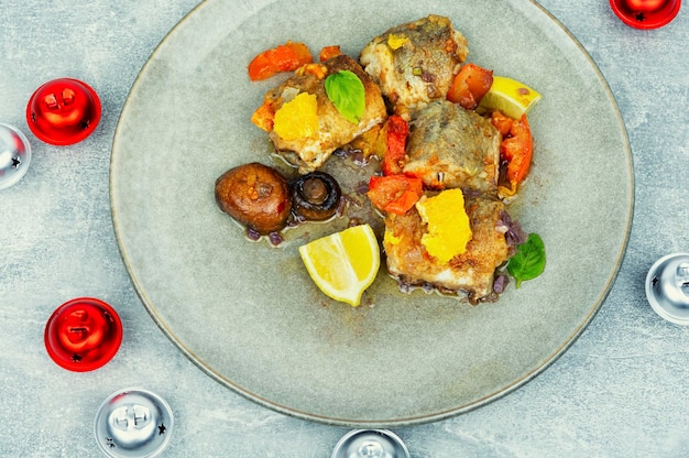 Nasello di pesce preparato con funghi e arance