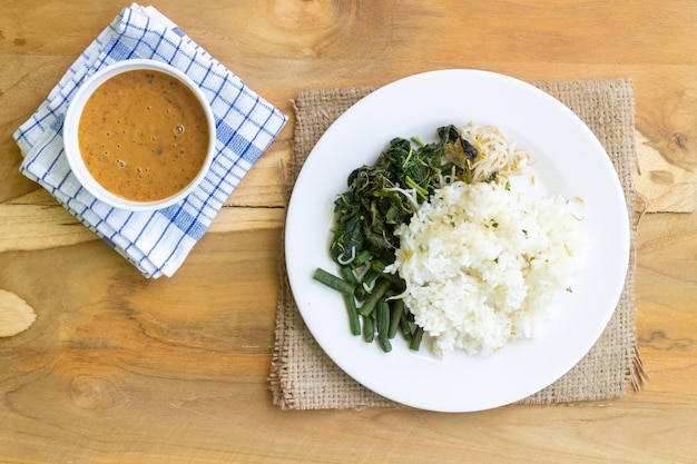 Nasi Pecel. Piatto di riso tradizionale giavanese di riso al vapore con insalata di verdure, salsa di arachidi, tempeh, beancurd e cracker.