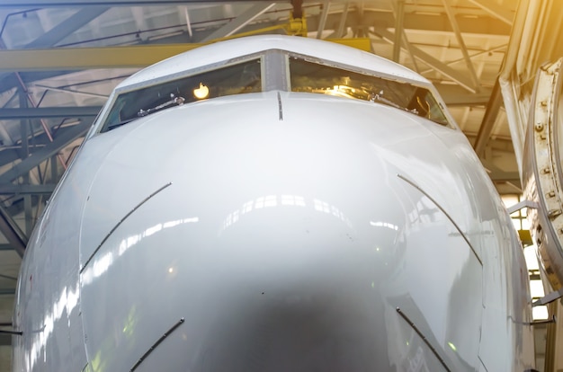 Naso dell'aereo e cabina di pilotaggio vicino all'hangar.