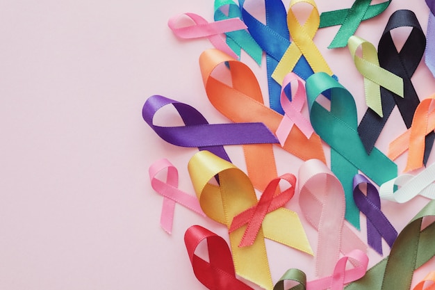 Nastri colorati su sfondo rosa, consapevolezza del cancro, giornata mondiale del cancro