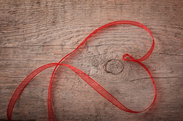 Nastro a forma di cuore di San Valentino su sfondo di legno