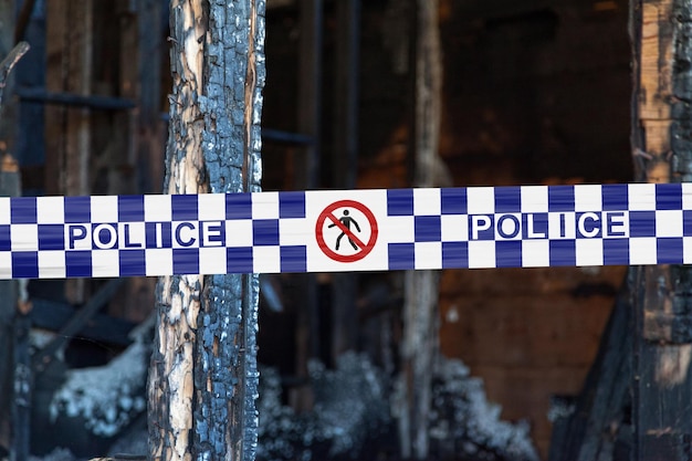 Nastro della polizia australiana che barrica una casa bruciata