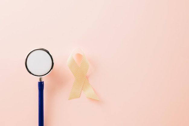 Nastro di consapevolezza rosa segno e stetoscopio della Giornata mondiale contro il cancro