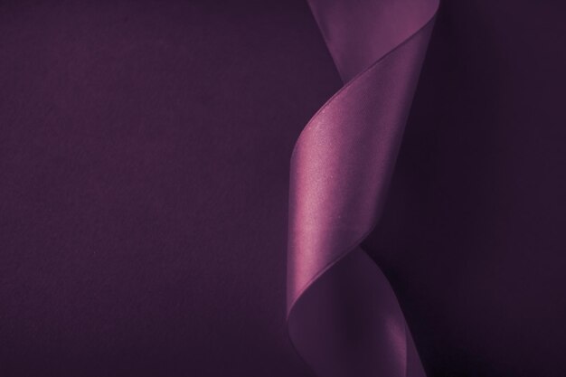 Nastro di seta riccio astratto su sfondo viola design esclusivo del marchio di lusso per la promozione del prodotto in vendita per le vacanze e lo sfondo della carta dell'invito di arte glamour