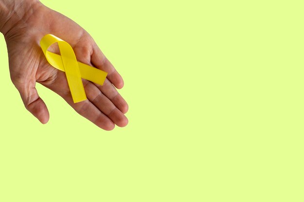 Nastro giallo nel palmo. campagna di prevenzione del suicidio. Settembre giallo.