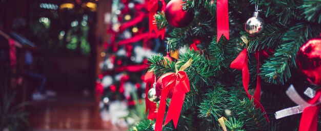 Nastro rosso con palline di Natale rosse e palline d'argento adornano l'albero di Natale Sfondo natalizio