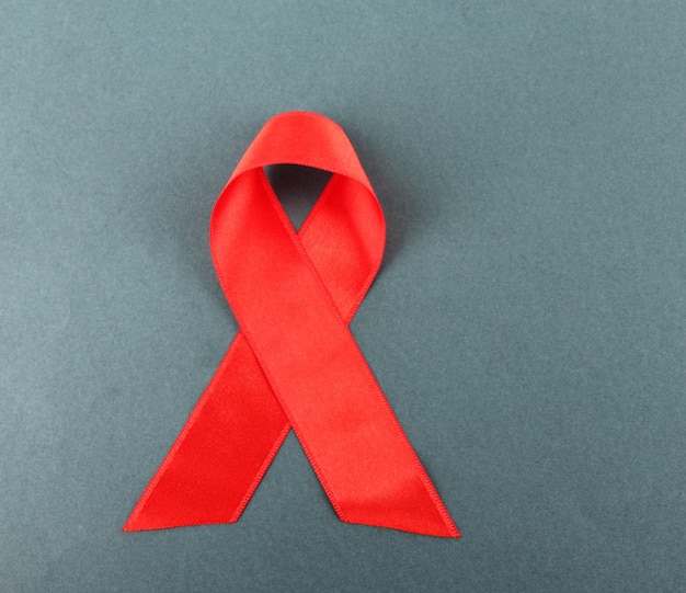 Nastro rosso HIV AIDS su sfondo grigio