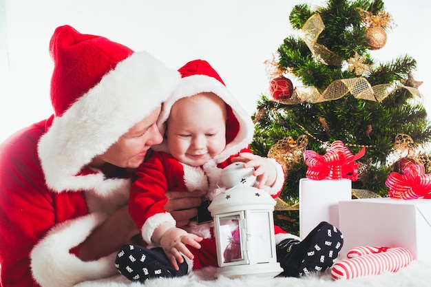 Natale bambino e mamma sotto l'abete isolato