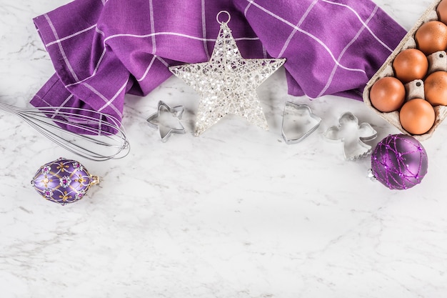 Natale cottura regali viola decorazioni uova e utensili da cucina sul tavolo di marmo.