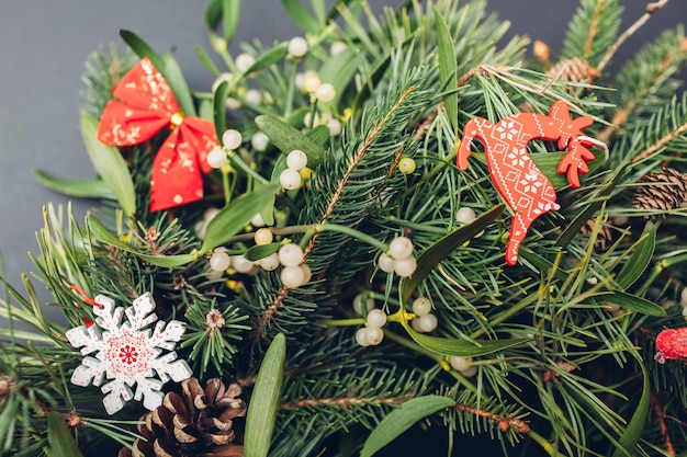 Natale e Capodanno abete fresco, pino, rami di vischio, pigne decorate con ornamenti rossi, fiocchi, giocattoli, cervi. Arte delle vacanze