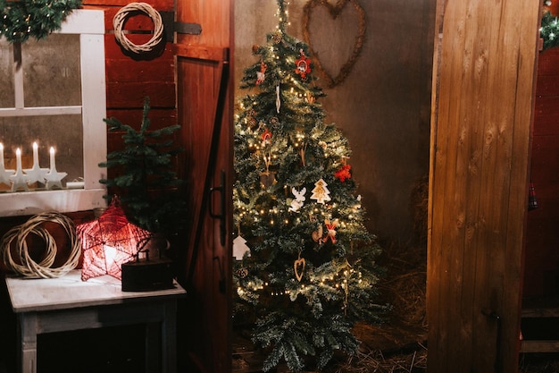 Natale e Capodanno albero di Natale decorato in stile scandinavo retrò vintage con giocattoli e ghirlande di luci luminose abete verde o abete rosso nel fienile stagione delle vacanze invernali in campagna