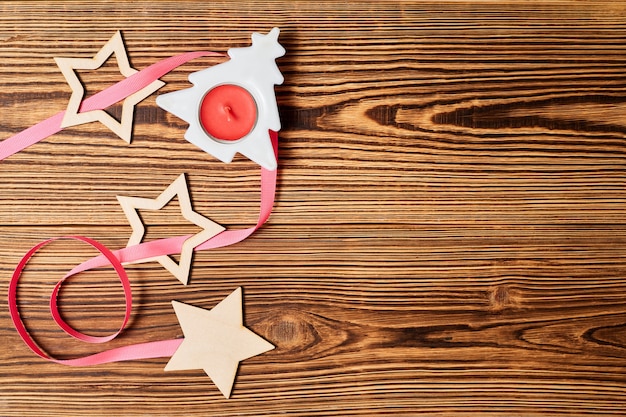 Natale Flatlay con stelle di candela albero di Natale e nastro rosa su sfondo di legno