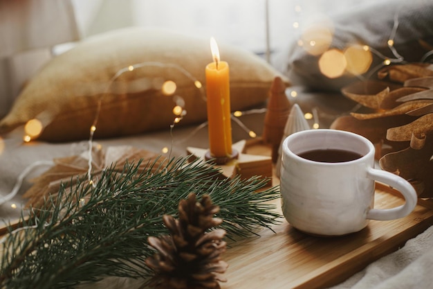 Natale hygge inverno Tazza di tè natale stelle luci dorate alberi candela Momento atmosferico