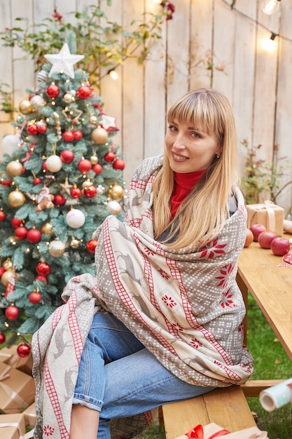 Natale in famiglia a luglio. Ritratto di ragazza vicino all'albero di Natale con regali. Decorare il pino. Vacanze invernali e concetto di persone. Cartolina d'auguri di buon Natale e buone feste. Natale donna