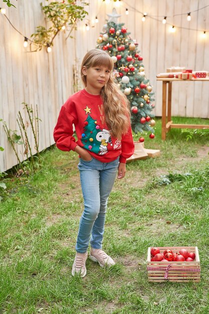 Natale in famiglia a luglio Ritratto di ragazza vicino all'albero di Natale con regali