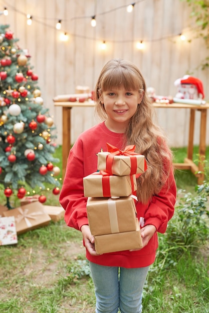 Natale in famiglia a luglio Ritratto di ragazza vicino all'albero di Natale con regali