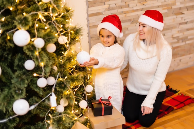 Natale, madre di famiglia felice con la figlia con regali alla vigilia di Natale