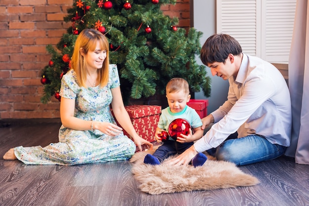 natale, natale, famiglia, persone, concetto di felicità - genitori felici che giocano con il neonato sveglio