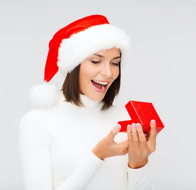 natale, natale, inverno, concetto di felicità - donna sorpresa con cappello da Babbo Natale con piccola scatola regalo