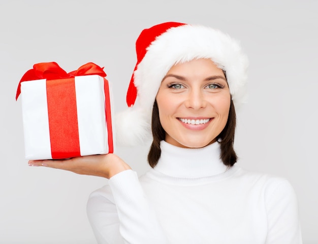 natale, natale, inverno, concetto di felicità - donna sorridente con cappello da Babbo Natale con scatola regalo