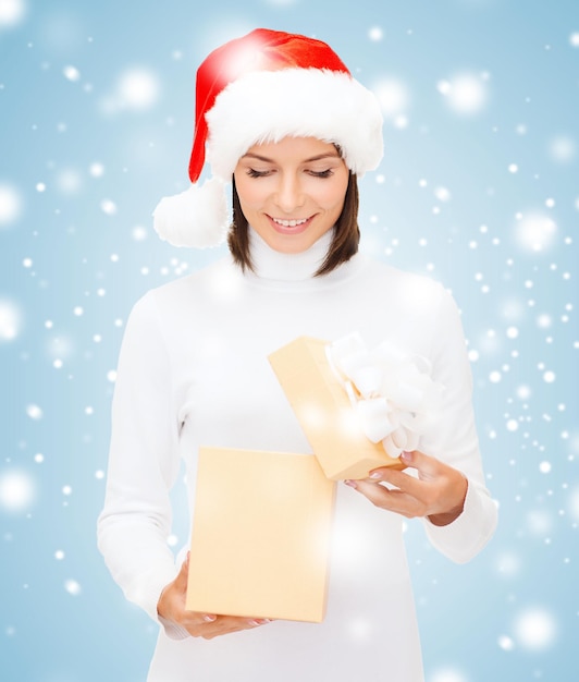 natale, natale, inverno, concetto di felicità - donna sorridente con cappello da Babbo Natale con scatola regalo