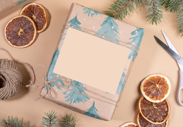 Natale o Capodanno fai da te avvolto in una confezione regalo di carta festiva con spazio vuoto su sfondo beige.