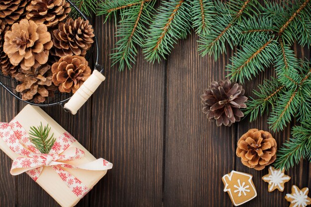 Natale o Capodanno. Rami di abete, giocattoli dell'albero di Natale, stelle, fiocco di neve e coni su legno marrone scuro.