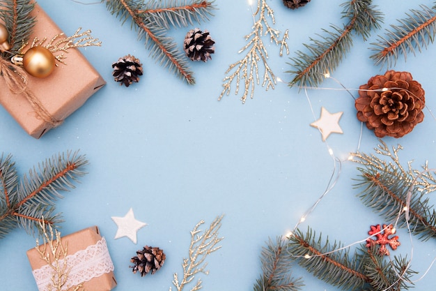 Natale piatto disteso. Foto di concetto Regalo di Natale, Capodanno. Abete e ramoscelli dorati, decorazioni, ghirlande su sfondo blu. Copia spazio