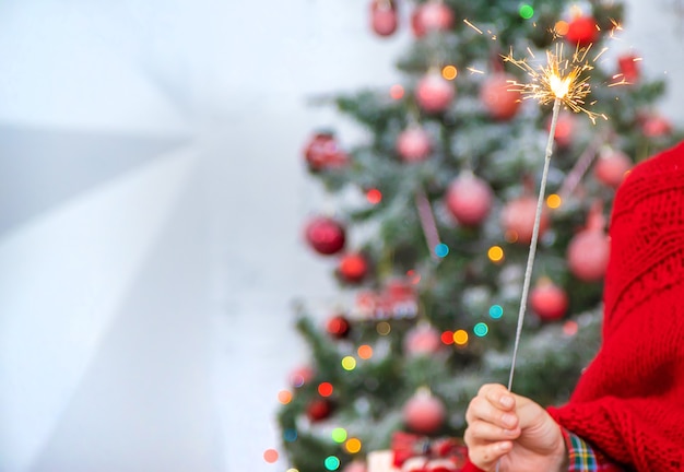 Natale, ragazza con le stelle filanti in mano. Messa a fuoco selettiva. Vacanza.