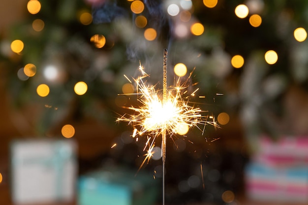 Natale scintillante scintillanti candele bruciate sullo sfondo dell'albero di Natale Decorazione di illuminazione natalizia a casa al coperto Festive Magia scintille luci per la festa di Natale Vigilia di Natale con fuochi d'artificio