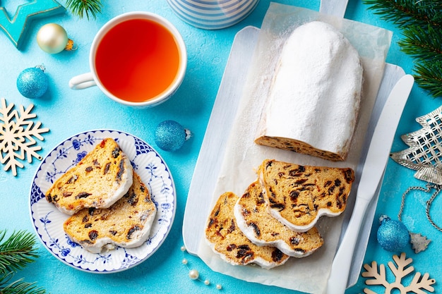 Natale stollen Dessert festivo tradizionale tedesco con tazza di tè Sfondo blu Vista dall'alto