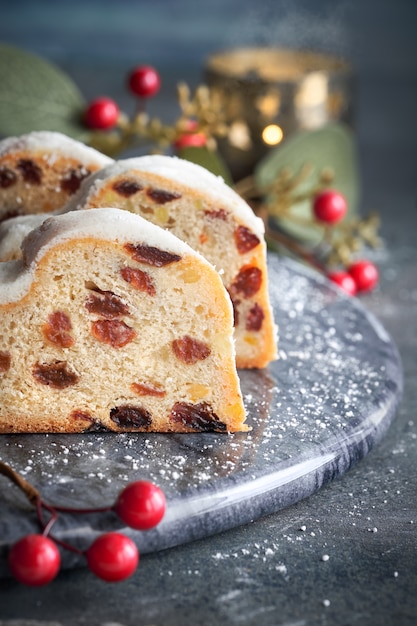 Natale stollen su scuro festivo con candela, bacche e foglie