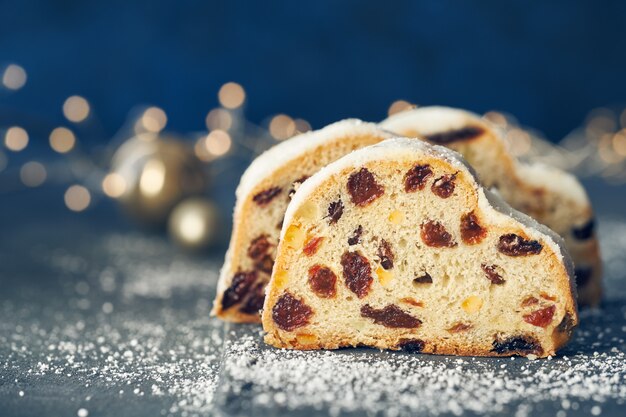 Natale stollen sulla composizione festiva blu scuro con luci di Natale