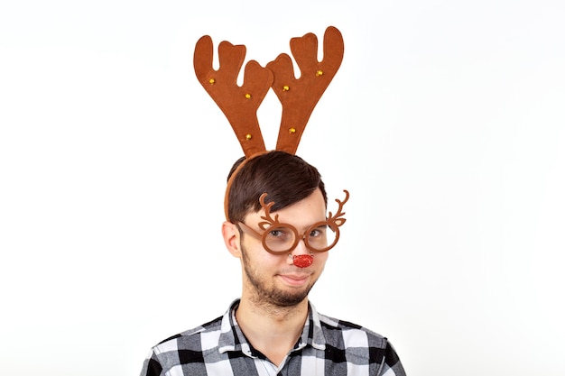 Natale, vacanze e concetto divertente - uomo con corna di cervo e rudolf nous su sfondo bianco