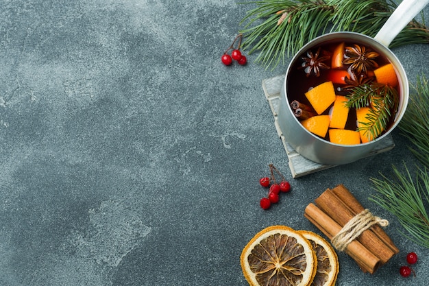 Natale vin brulè con spezie e frutta sul tavolo.