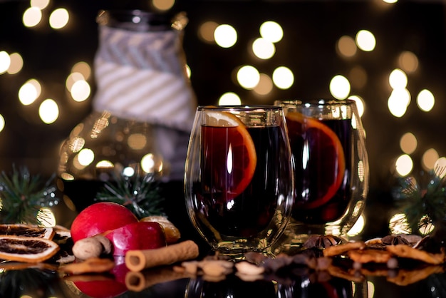 Natale vin brulé di vino rosso con spezie e frutta su sfondo nero bere a Natale