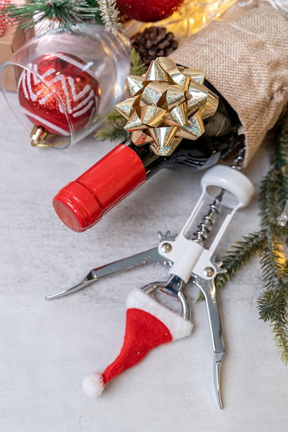 Natale Vino rosso e apribottiglie con decorazione cappello santa sullo sfondo della tavola.