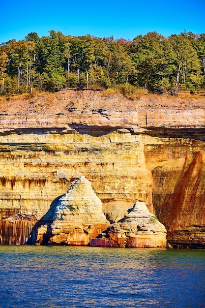 National Park Pictured Rocks è crollata una parete rocciosa che si protende dall'acqua del lago indaco con la foresta sopra