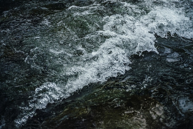 Natura del flusso di acqua scura del fiume di montagna