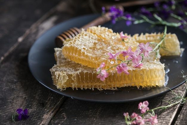 Natura mestolo di miele in legno e favi su sfondo di legno